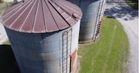 an aerial view of two rusty silos